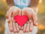 Male hands holding a red heart